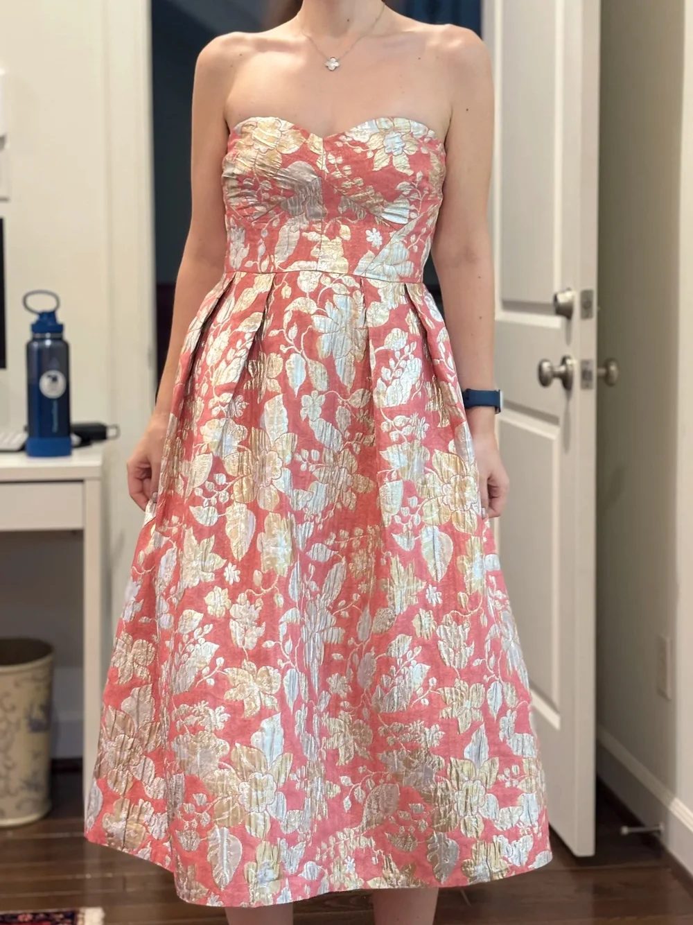 A strapless gown in coral and gold brocade